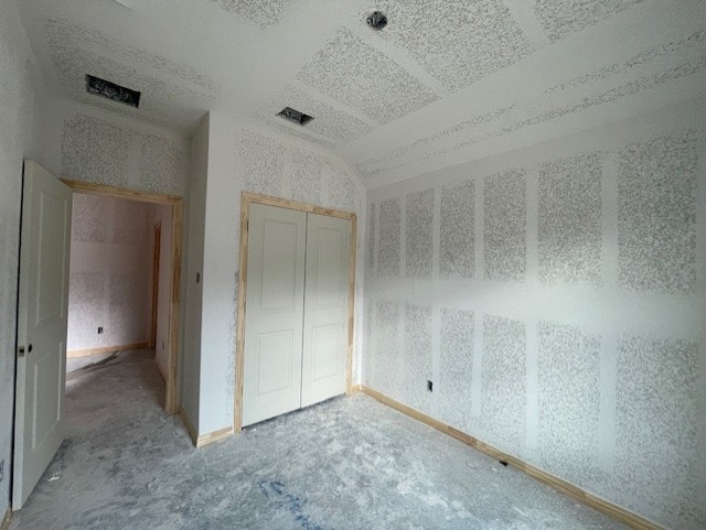 unfurnished bedroom featuring vaulted ceiling and a closet