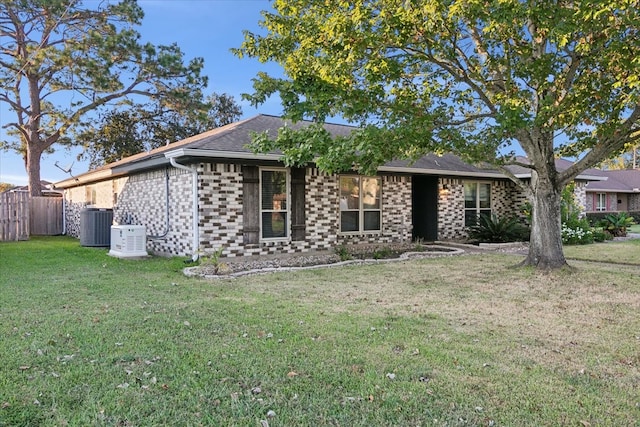 view of front of home featuring cooling unit and a front yard