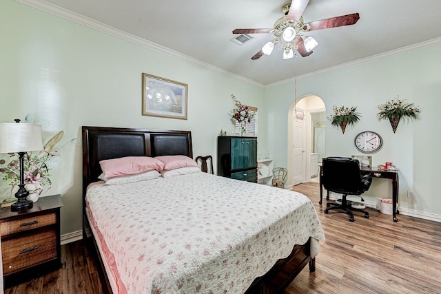 bedroom with hardwood / wood-style flooring, ornamental molding, and ceiling fan