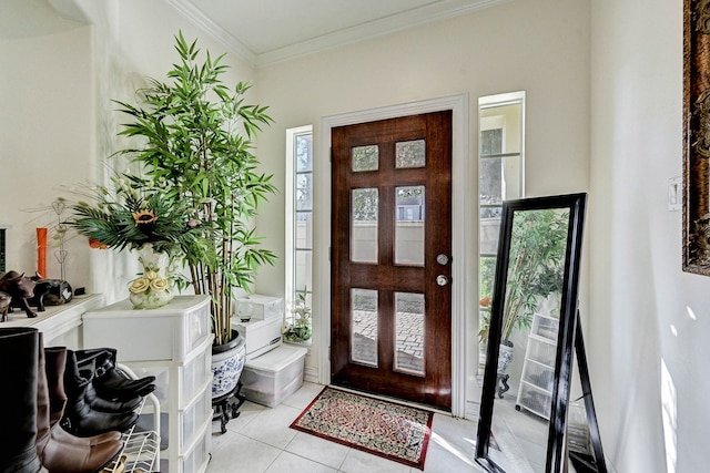 tiled foyer with ornamental molding, french doors, and a healthy amount of sunlight