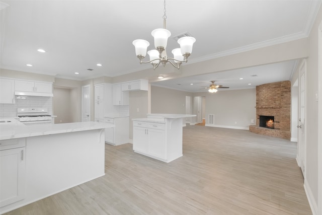 kitchen featuring white cabinets, decorative backsplash, white range, and a large fireplace