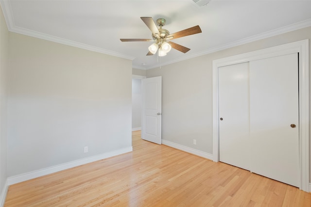 unfurnished bedroom featuring a closet, ceiling fan, light hardwood / wood-style flooring, and crown molding