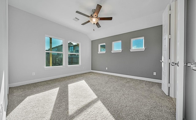 spare room featuring lofted ceiling, baseboards, visible vents, and light colored carpet