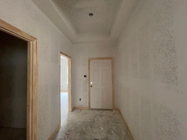 hallway featuring a tray ceiling