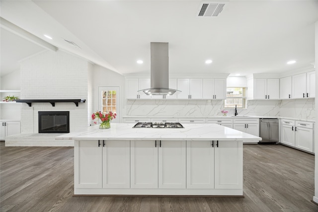 kitchen featuring island range hood, light stone countertops, lofted ceiling, and a healthy amount of sunlight