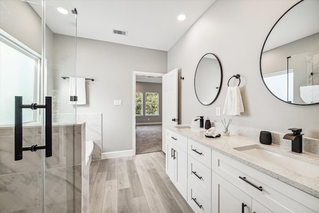 bathroom with hardwood / wood-style flooring, vanity, and separate shower and tub