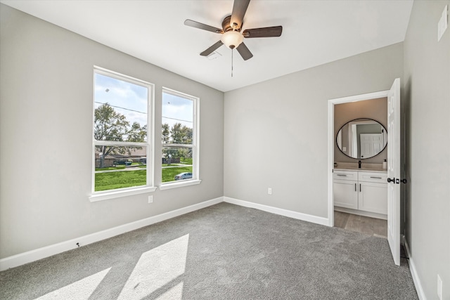 unfurnished bedroom with ceiling fan, connected bathroom, and carpet flooring