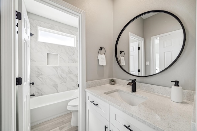 full bathroom with toilet, vanity, tiled shower / bath, and hardwood / wood-style flooring