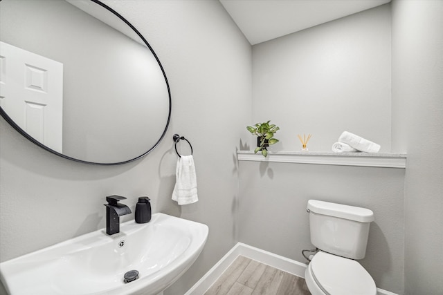 bathroom featuring wood-type flooring, sink, and toilet