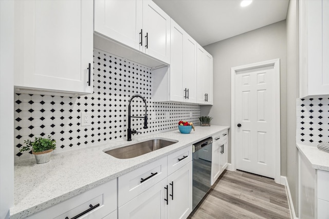 kitchen with white cabinetry, sink, backsplash, light wood-type flooring, and dishwasher