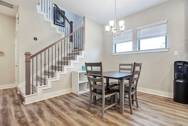 dining space featuring hardwood / wood-style floors and an inviting chandelier