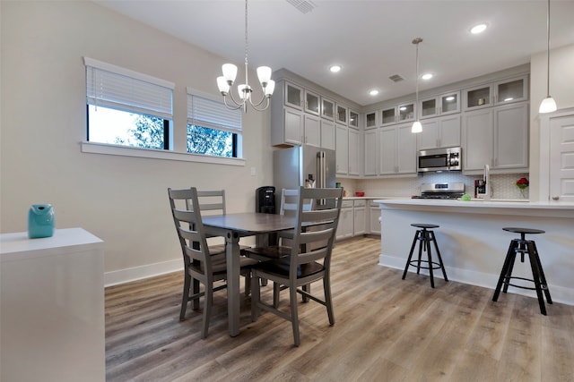 dining space with a notable chandelier and light wood-type flooring