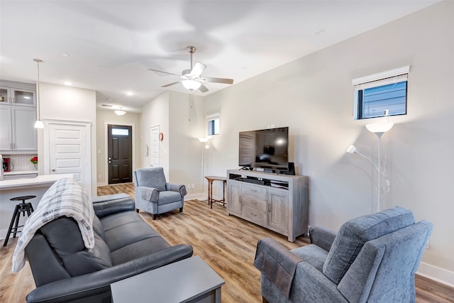 living room with ceiling fan and light wood-type flooring