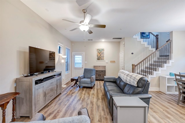 living room with light hardwood / wood-style floors and ceiling fan