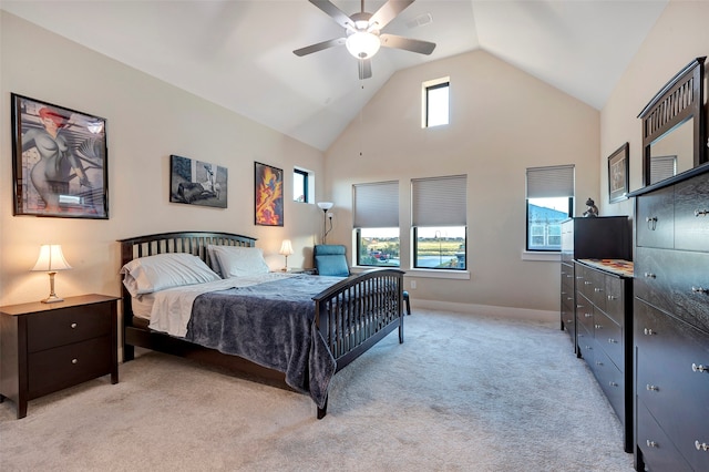 carpeted bedroom with ceiling fan and high vaulted ceiling