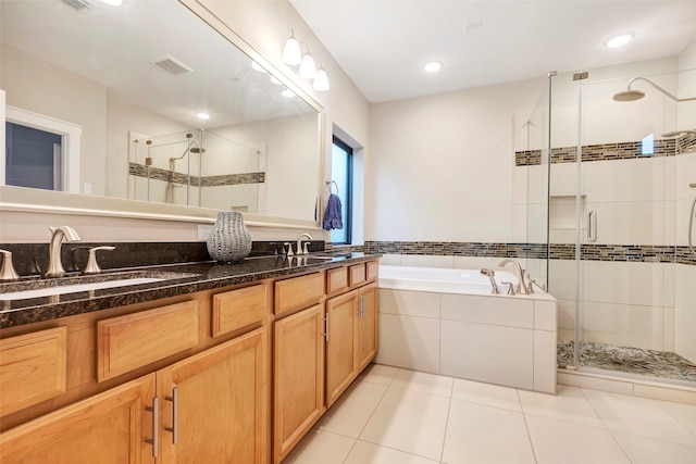 bathroom with tile patterned floors, vanity, and shower with separate bathtub