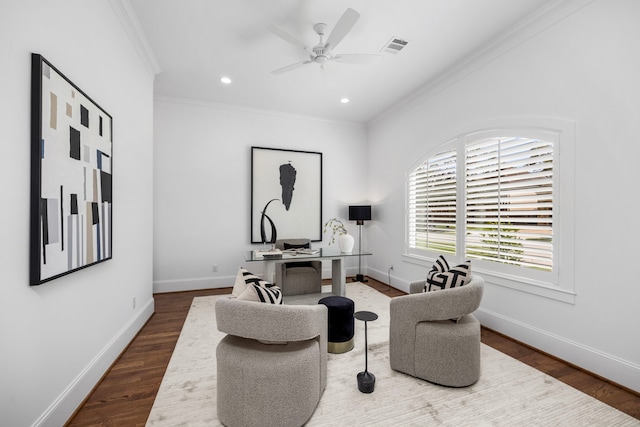 sitting room with baseboards, visible vents, ceiling fan, ornamental molding, and wood finished floors