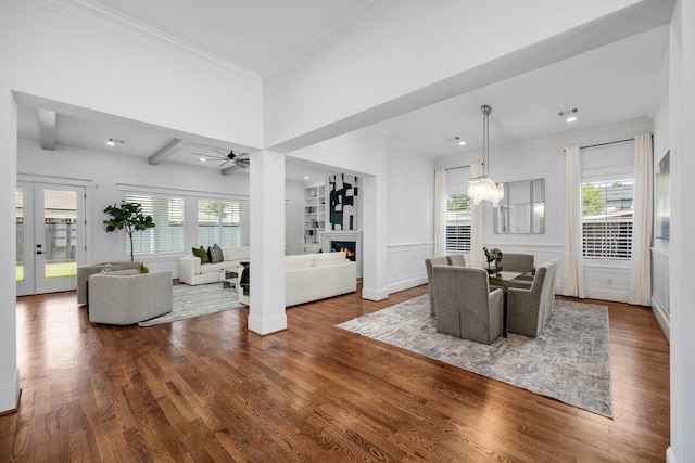 dining area featuring beam ceiling, hardwood / wood-style flooring, a healthy amount of sunlight, and ceiling fan with notable chandelier