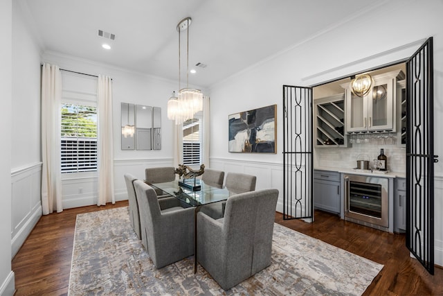 dining space featuring crown molding, wine cooler, and dark hardwood / wood-style flooring