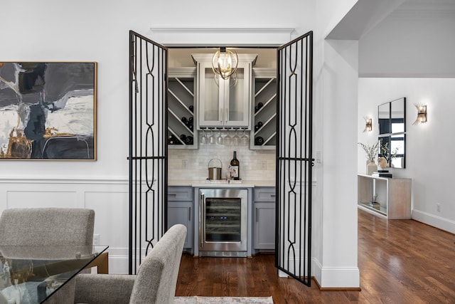 bar featuring gray cabinets, wine cooler, dark hardwood / wood-style flooring, and tasteful backsplash