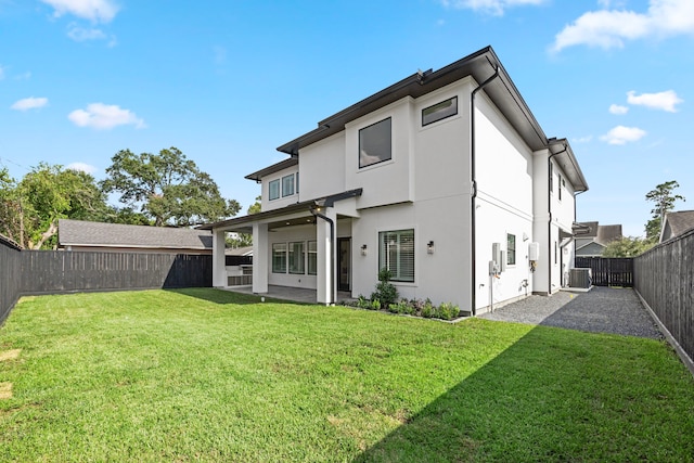 back of property with a patio, cooling unit, a fenced backyard, a yard, and stucco siding