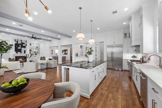 kitchen featuring white cabinetry, decorative light fixtures, dark hardwood / wood-style flooring, high end appliances, and a center island