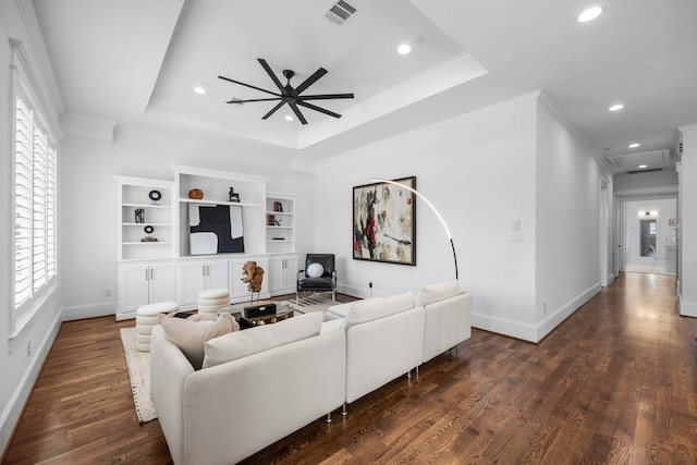 living area featuring dark wood-style floors, visible vents, a raised ceiling, and crown molding