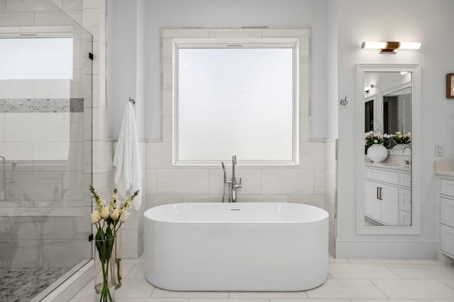 bathroom featuring a freestanding bath, a shower stall, and vanity