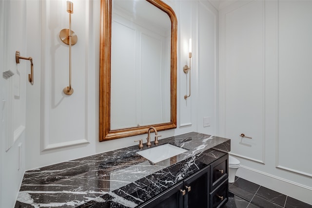 bathroom featuring tile patterned flooring, vanity, and toilet