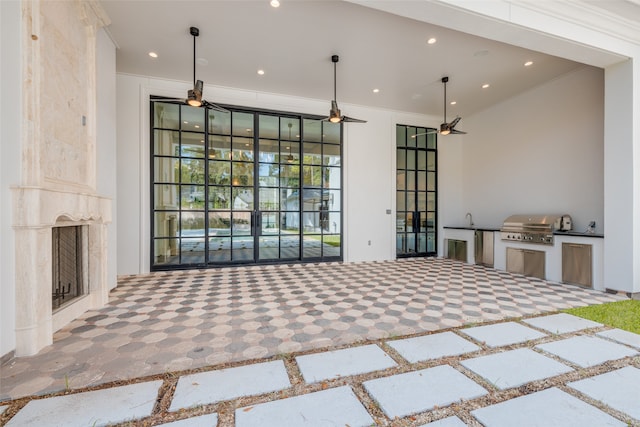 interior space featuring a large fireplace, ornamental molding, and sink