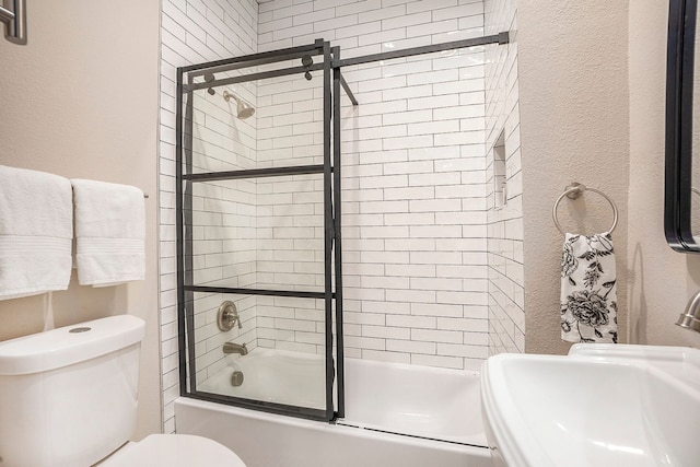 full bathroom featuring sink, toilet, and bath / shower combo with glass door