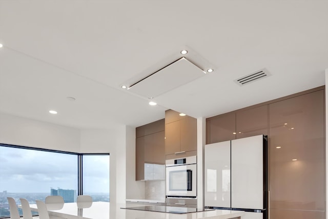 kitchen featuring a wealth of natural light, white fridge, decorative backsplash, and gray cabinets