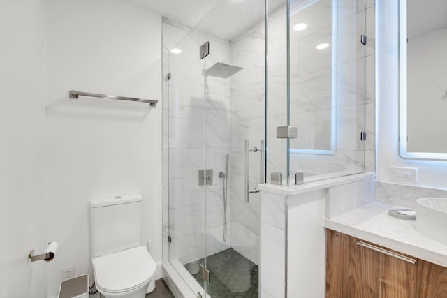 bathroom featuring vanity, toilet, and a shower with shower door