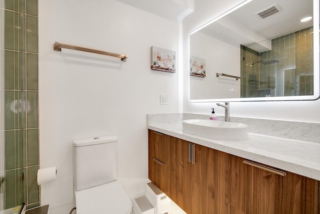 bathroom featuring vanity, toilet, and a shower with shower door