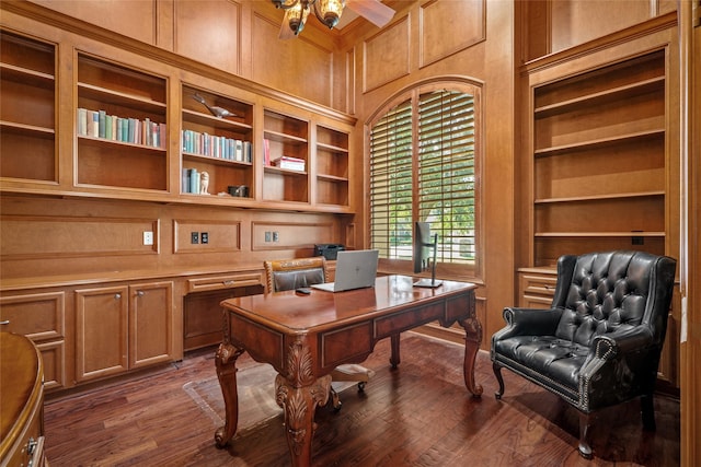 office area featuring a towering ceiling, dark hardwood / wood-style floors, and wood walls