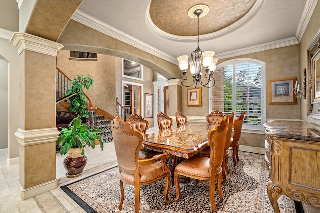 dining area featuring a tray ceiling, crown molding, and a notable chandelier