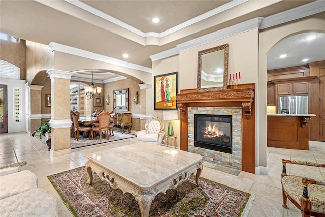 living room with crown molding, a fireplace, light tile patterned flooring, and an inviting chandelier