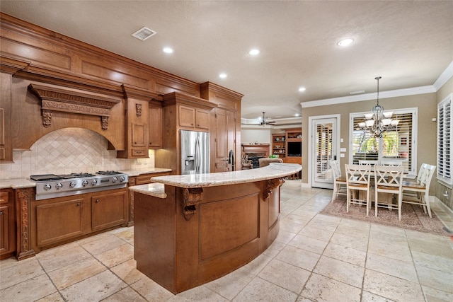 kitchen featuring appliances with stainless steel finishes, backsplash, ornamental molding, a kitchen island, and hanging light fixtures