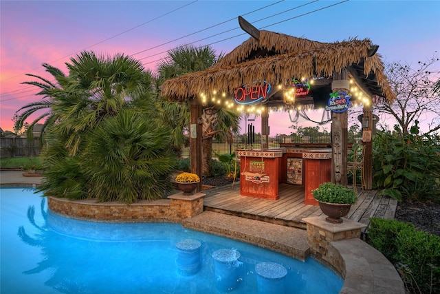 pool at dusk featuring a wooden deck