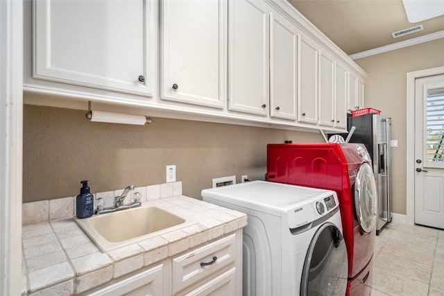 laundry area featuring cabinets, ornamental molding, sink, washer and dryer, and light tile patterned flooring