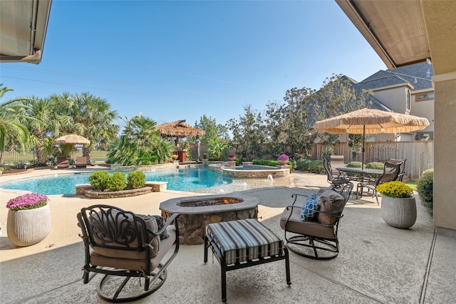 view of swimming pool with a patio, an in ground hot tub, and an outdoor fire pit