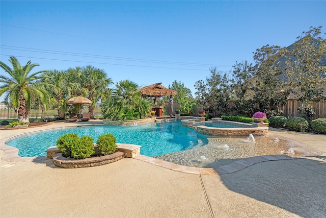 view of swimming pool with pool water feature, a patio area, and an in ground hot tub