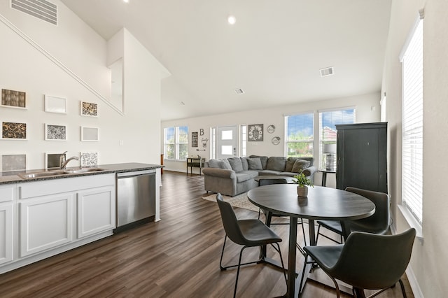 dining space featuring dark wood-type flooring, high vaulted ceiling, and sink