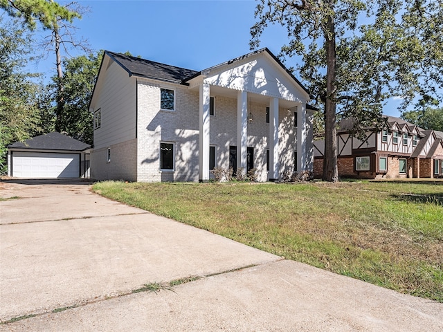 view of front of house with a front yard, a garage, an outdoor structure, and a porch