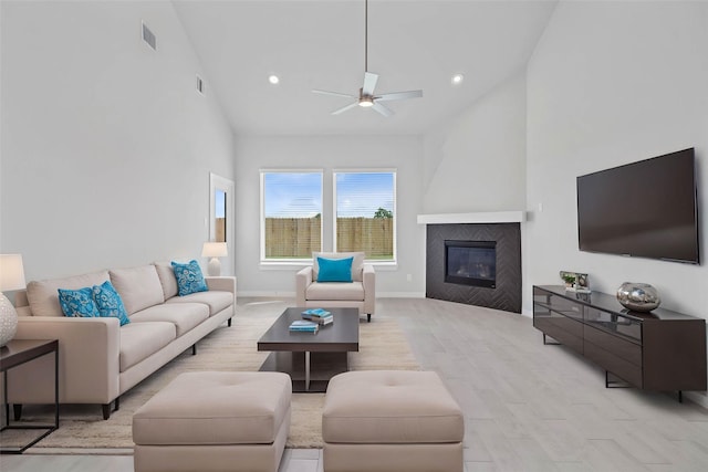 373 Spruce Oak Ln, Waller, TX 77484 - living room with ceiling fan, high vaulted ceiling, light wood-style flooring, a glass covered fireplace, and recessed lighting