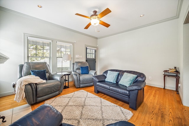 living room with light hardwood / wood-style floors, ceiling fan, and crown molding