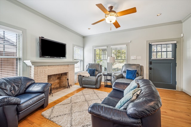 living room with ornamental molding, a fireplace, and light hardwood / wood-style flooring