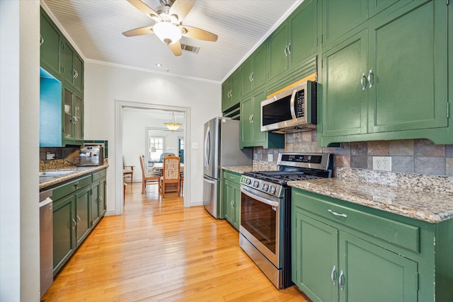 kitchen featuring stainless steel appliances, light hardwood / wood-style floors, and green cabinetry