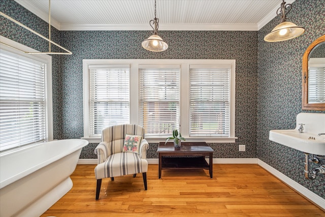 living area featuring ornamental molding, hardwood / wood-style floors, and a healthy amount of sunlight