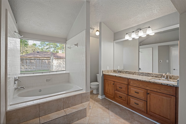 bathroom featuring a textured ceiling, vanity, tiled bath, tile patterned floors, and toilet